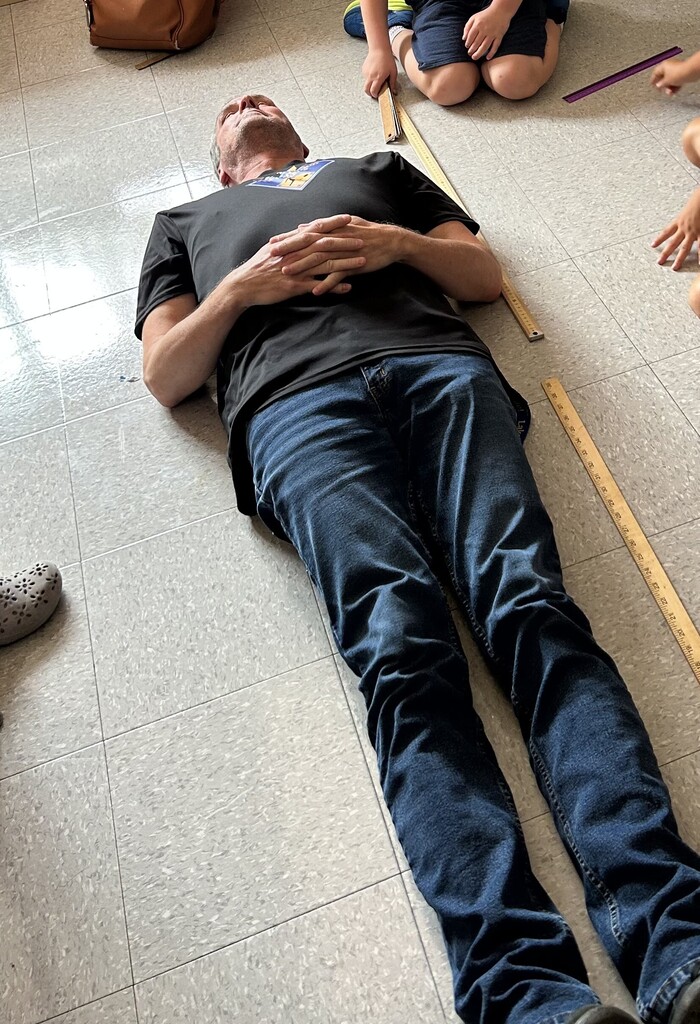 man lyin gon floor being measured