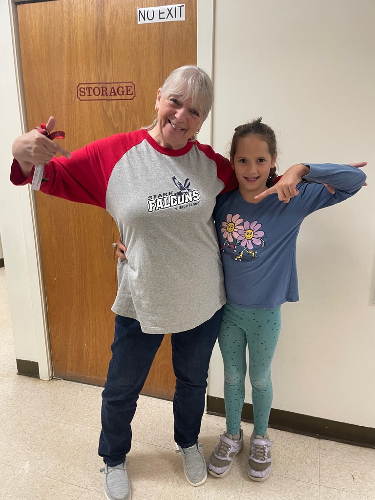 student points at staff member wearing the school shirt. 