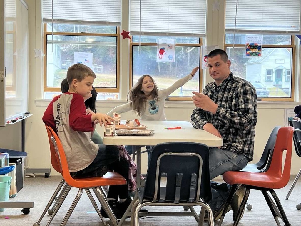Veterans and students seated at tables. 