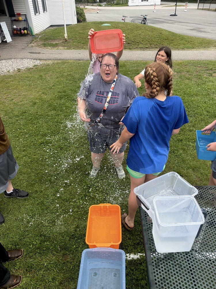 student pouring water on another student