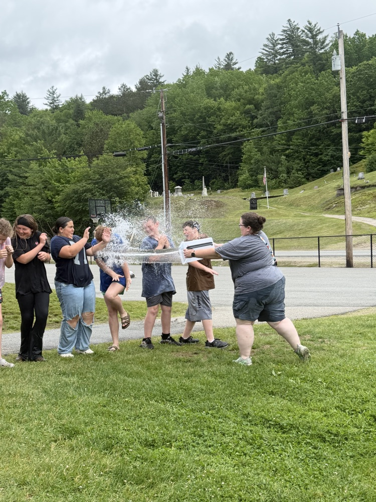 student pouring water on another student