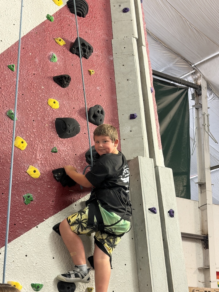 student climbing rock wall 