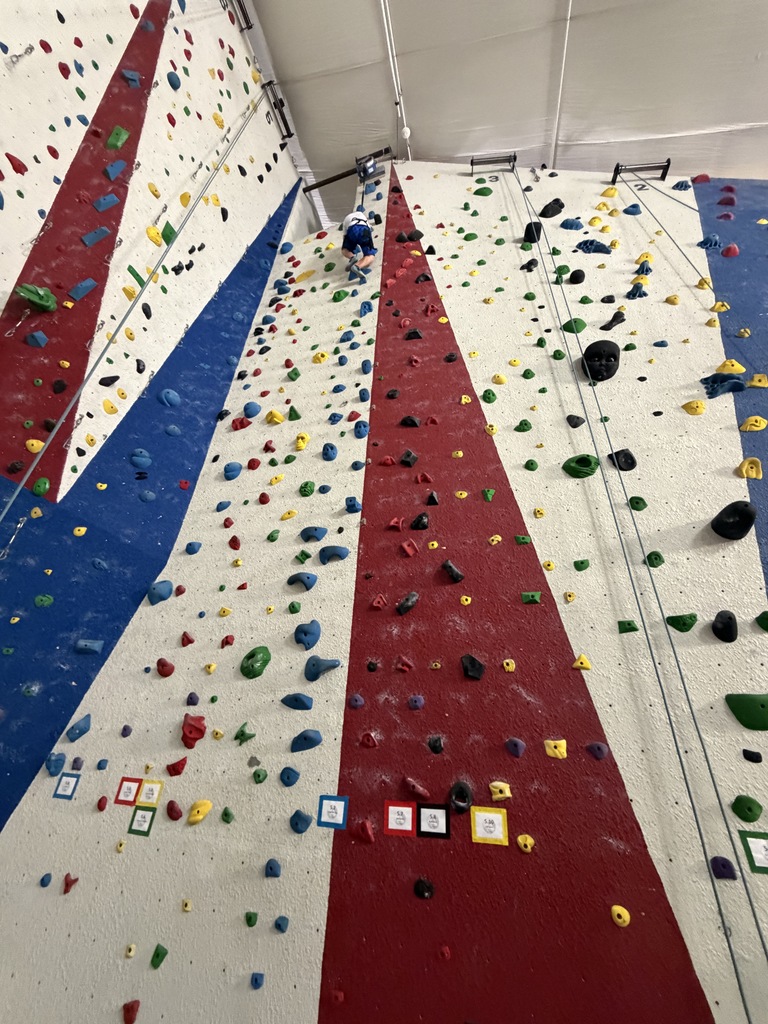 student climbing rock wall 