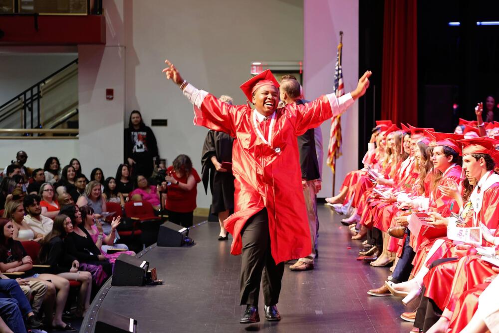 Excited graduate walking across the stage