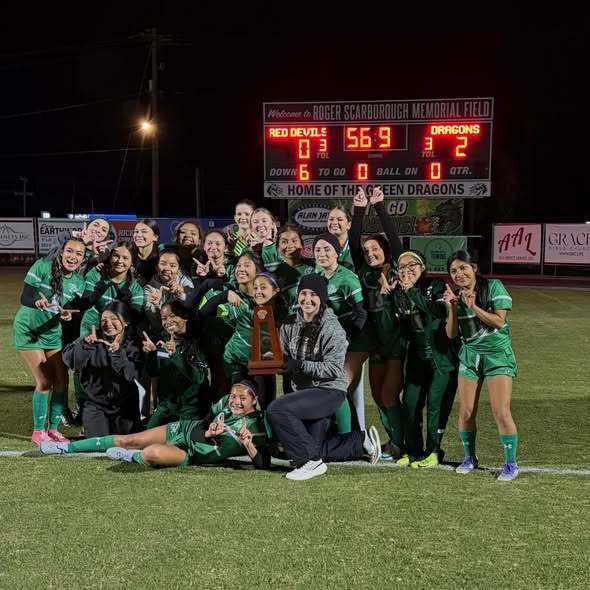 Soccer team infront of score board celebrating