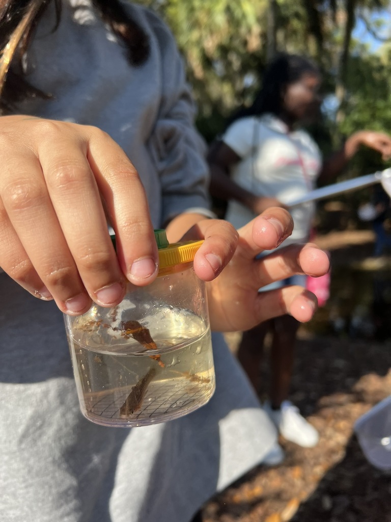 Student holding fish in jar 