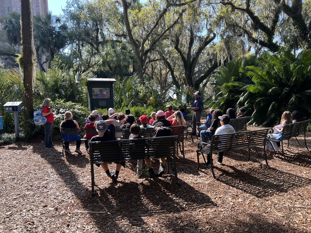 Students outside listening to a presentation 