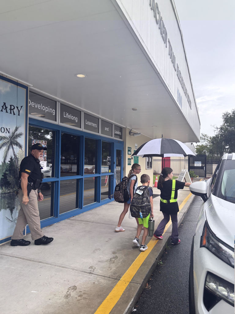 photo of safety patrol helping children in car