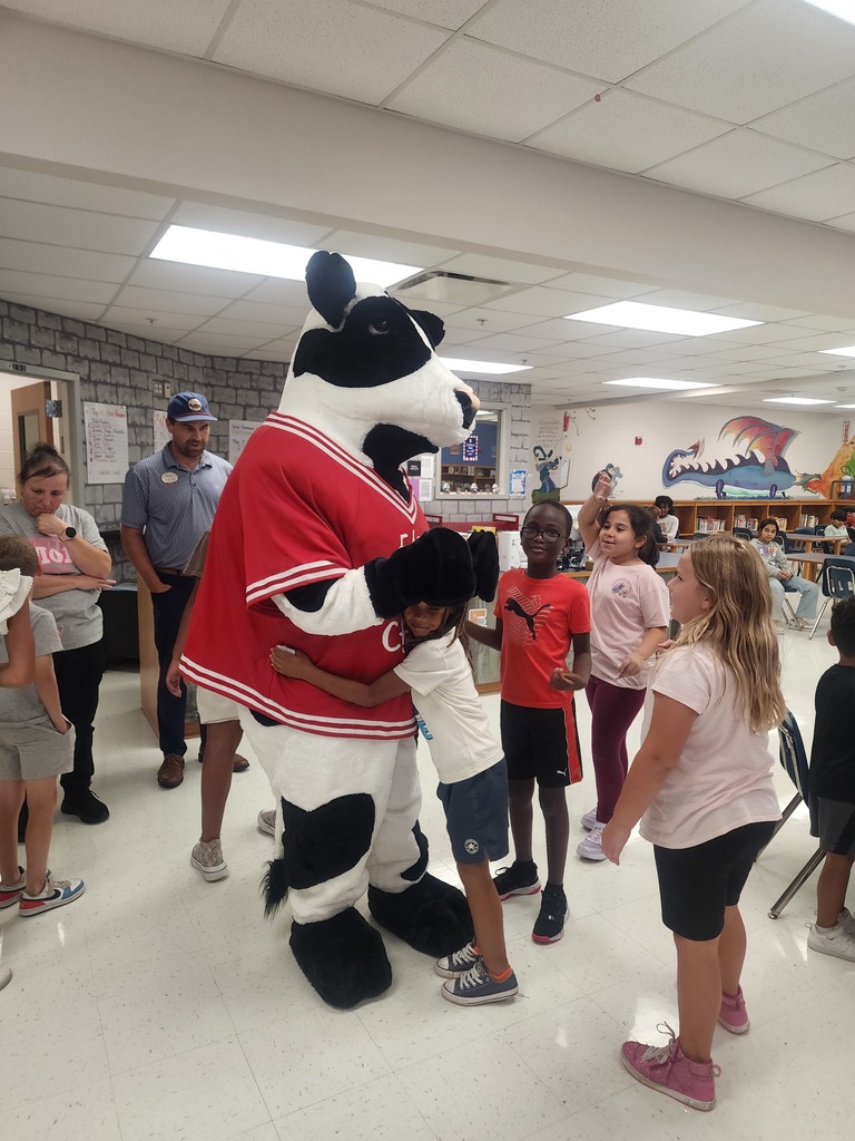 Chick Fil A cow visiting MES daycare as part of the company Million Book give away. Students and cow present in the pictures.
