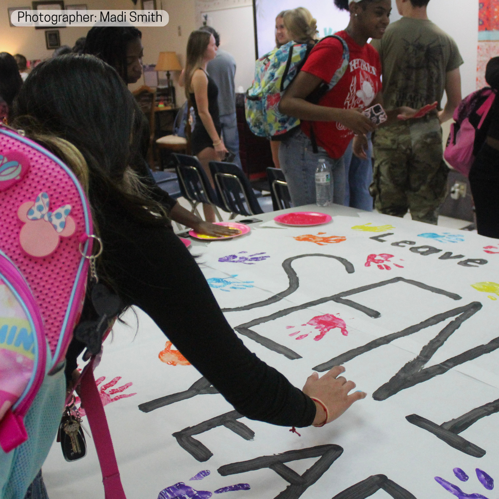 Seniors painting handprint sign.