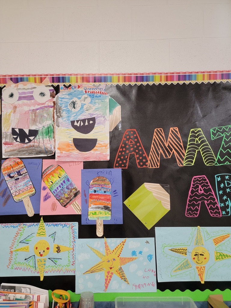 A classroom bulletin board displays student artwork focused on line and color. The top row features circular lion faces with brightly colored manes made of different patterns and lines. Below them are landscape scenes with sunsets over water, waves, trees, and mountains. At the bottom, two rectangular pieces show a red and white lighthouse with sun rays and a beach scene labeled “Florida” with palm trees and a chair. The board sections are labeled for 3rd, 4th, and 5th grades.