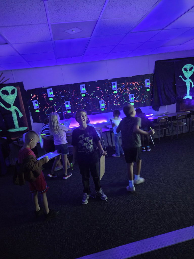 photos of students solving math problems in the classroom (glow in the dark theme)