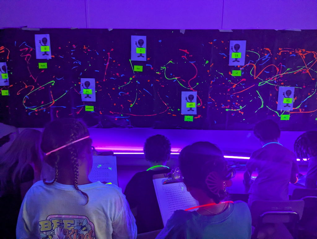 photos of students solving math problems in the classroom (glow in the dark theme)