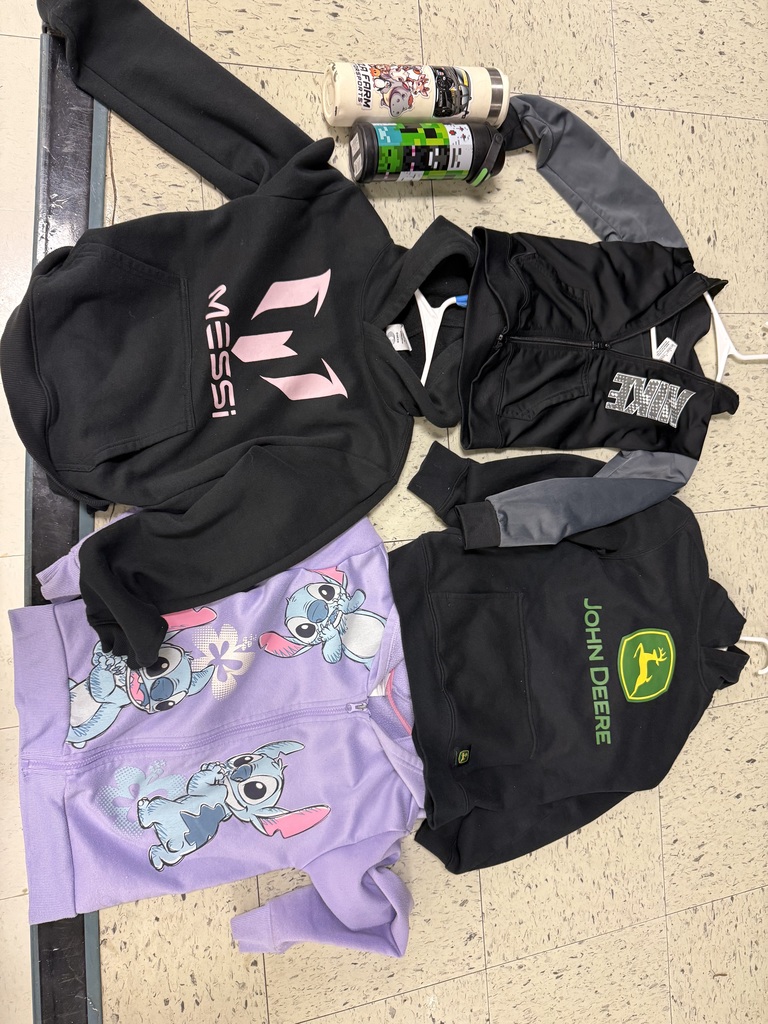 Several pieces of clothing and two water bottles: a black Messi hoodie, a purple Stitch zip-up, a black Nike zip-up, and a black John Deere hoodie.