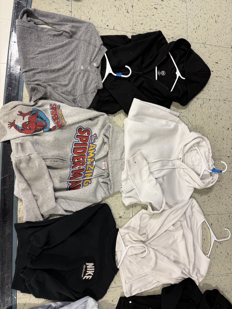 : Various tops including a gray henley shirt, a gray Amazing Spider-Man zip-up, black and white hoodies, and a black Nike sweatshirt.