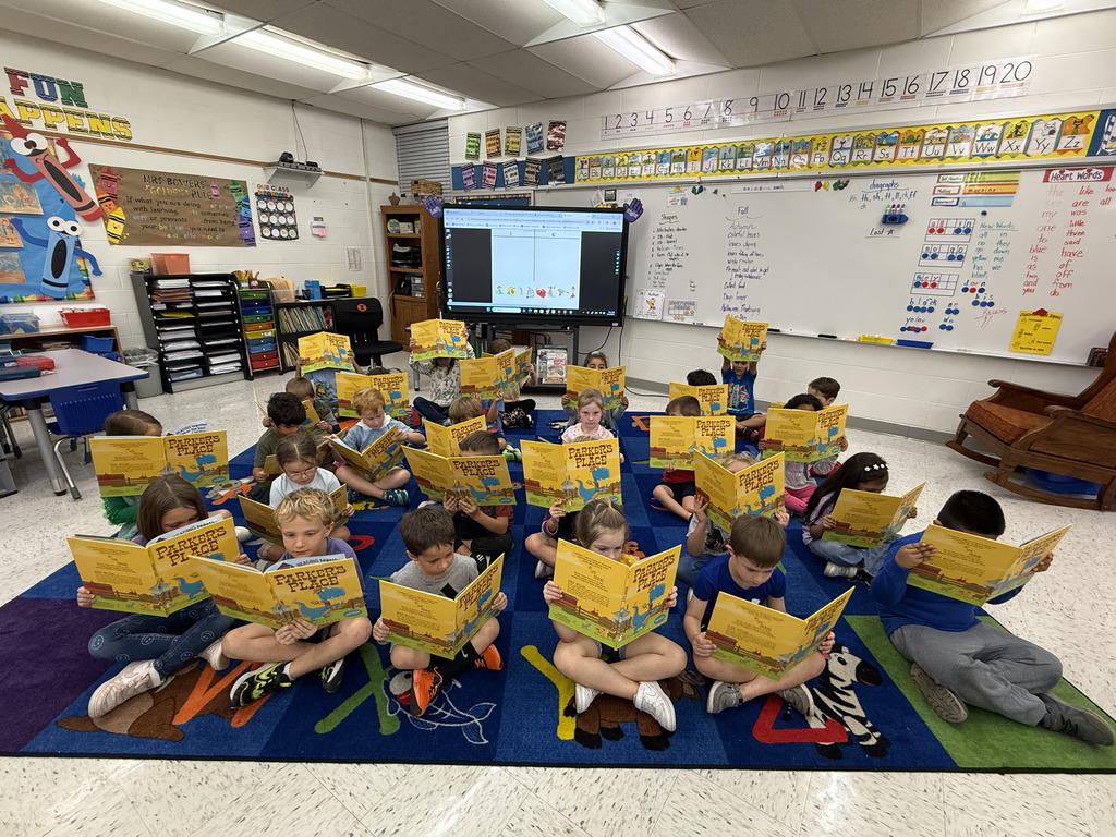 students holding up books reading
