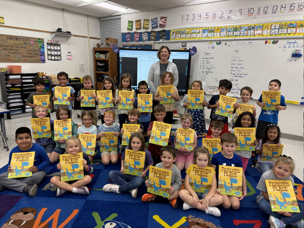 students showing off their books with the reader