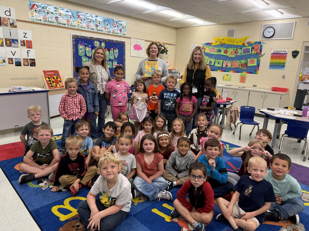 classroom of students, teachers, and reader smiling