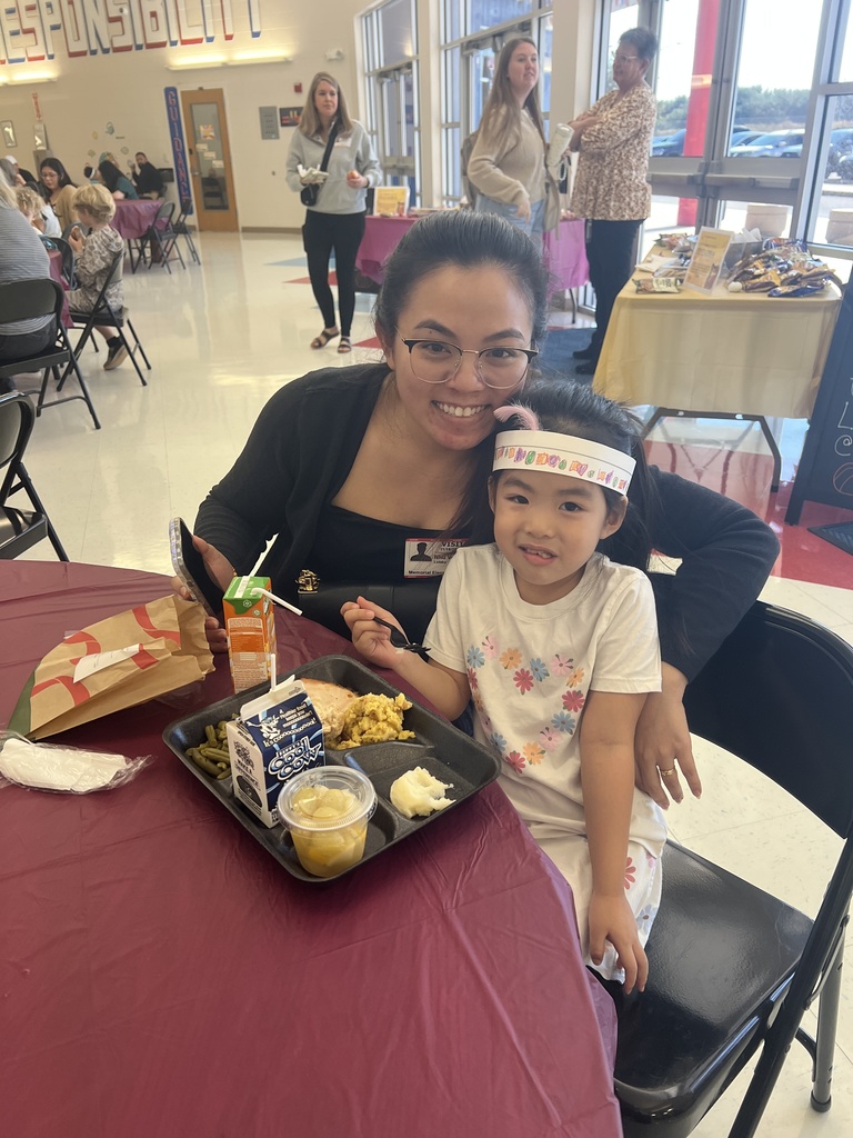 MES families enjoying Thanksgiving lunch with their child.