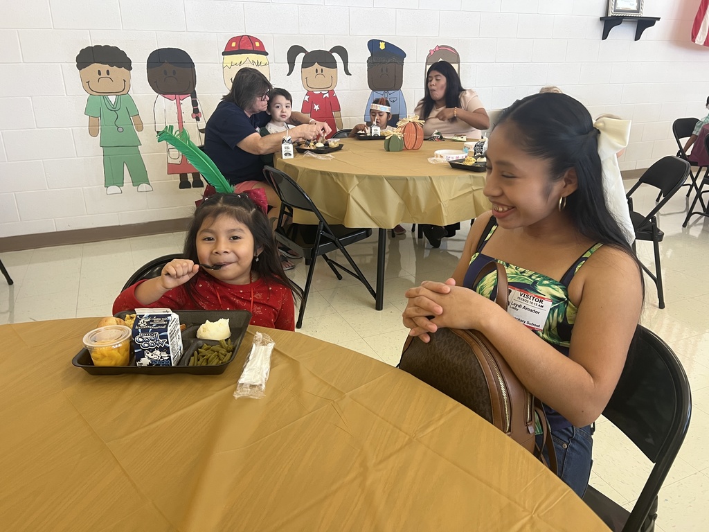 MES families enjoying Thanksgiving lunch with their child.