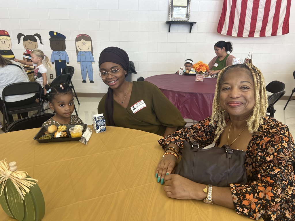MES families enjoying Thanksgiving lunch with their child.