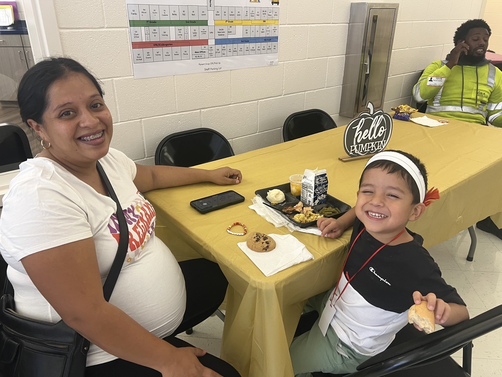MES families enjoying Thanksgiving lunch with their child.