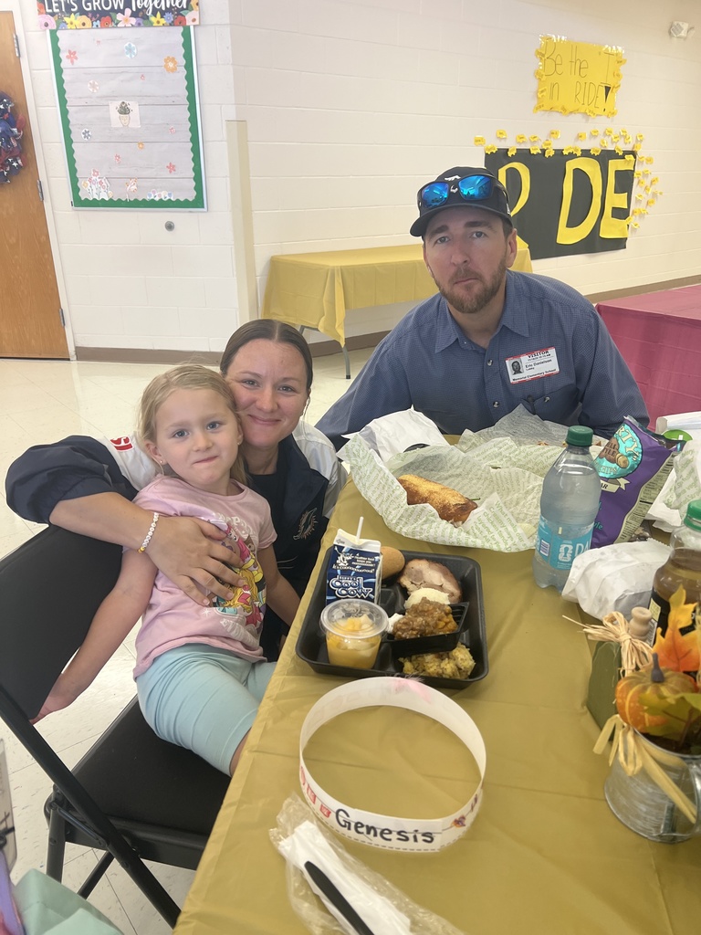 MES families enjoying Thanksgiving lunch with their child.