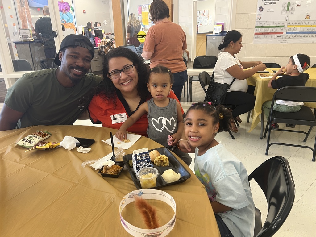 MES families enjoying Thanksgiving lunch with their child.