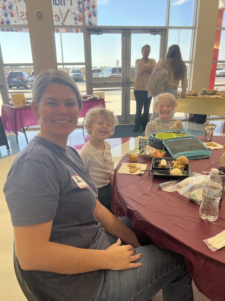 MES families enjoying Thanksgiving lunch with their child.