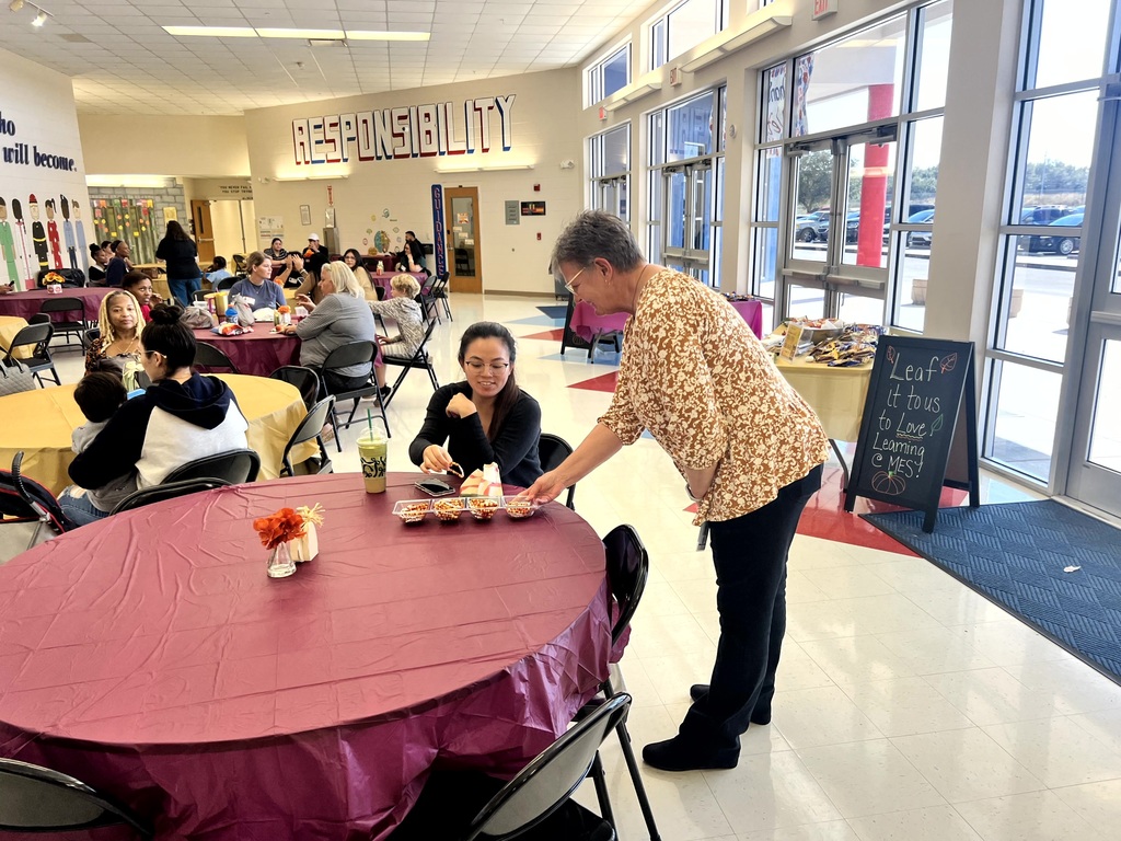MES families enjoying Thanksgiving lunch with their child.