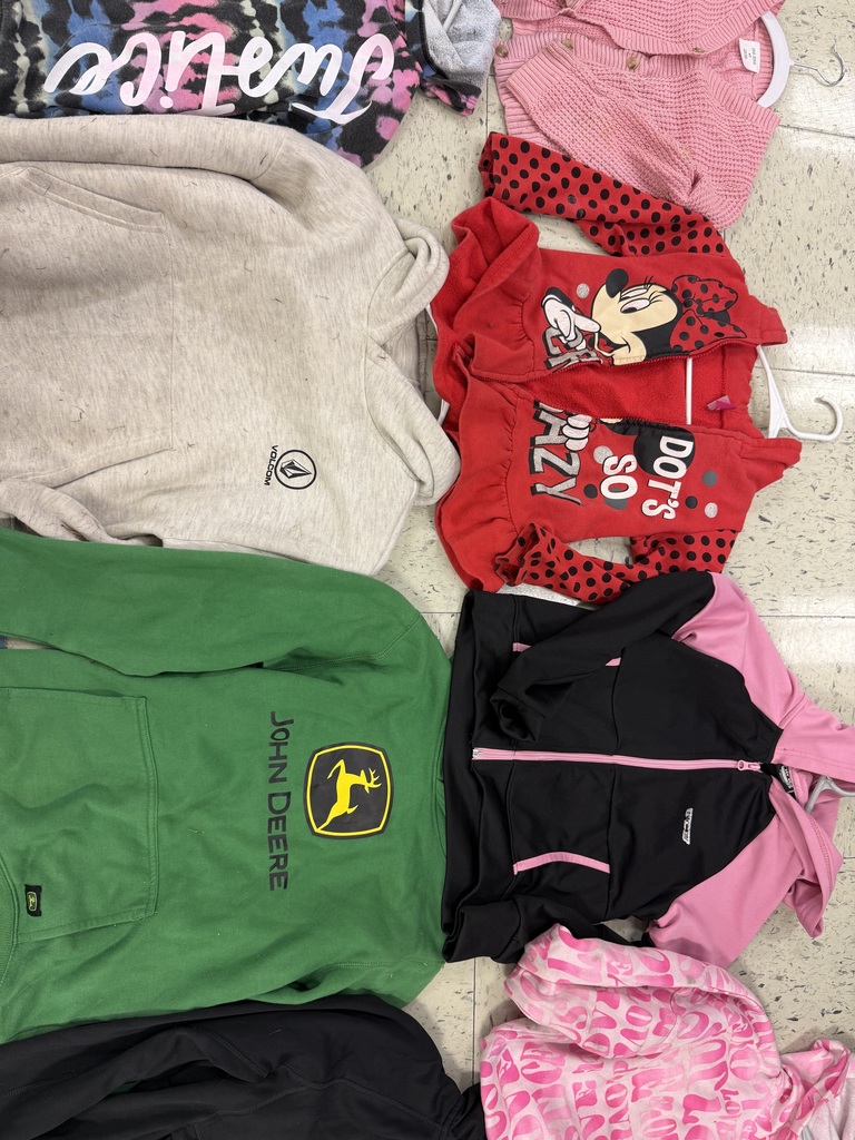 Children's outerwear includes a gray Volcom hoodie, a red Minnie Mouse hoodie, a green John Deere hoodie, a black and pink athletic jacket, a pink patterned jacket, and a pink knit cardigan.