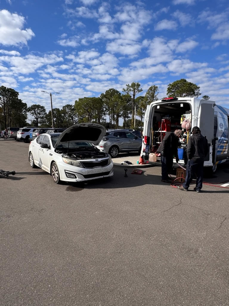 Hard working crew from Bill Jarrett Ford's mobile oil unit changing staff member's oil.