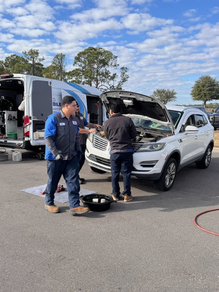 Hard working crew from Bill Jarrett Ford's mobile oil unit changing staff member's oil.