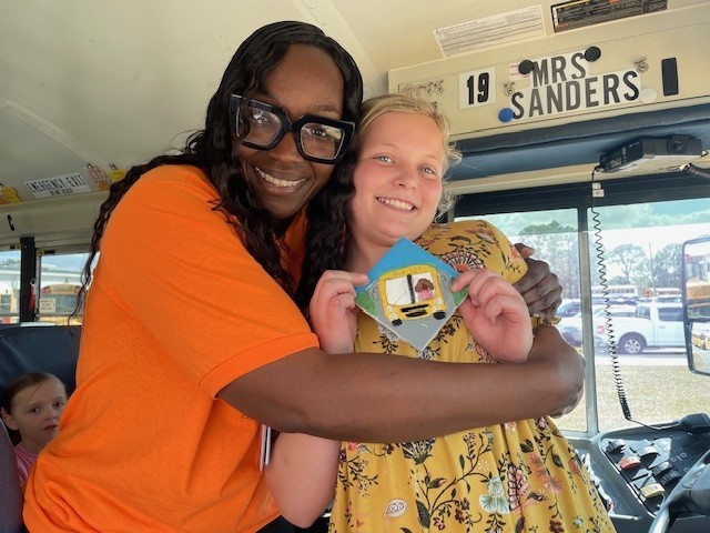 Bus driver and student celebrating tile.