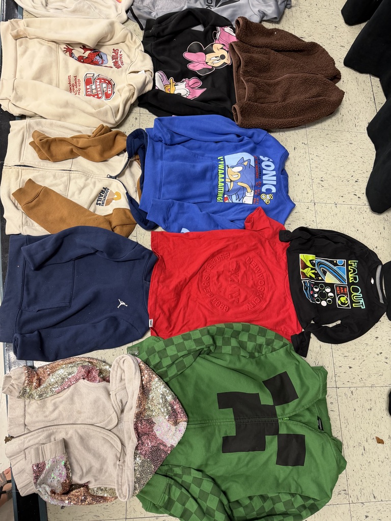 Multiple character-themed tops: a beige Spiderman sweatshirt, a black Minnie Mouse sweatshirt, a blue Sonic the Hedgehog hoodie, a green Minecraft Creeper zip-up, a tan sequined hoodie, a red embossed shirt, and a black "Far Out" space-themed shirt.