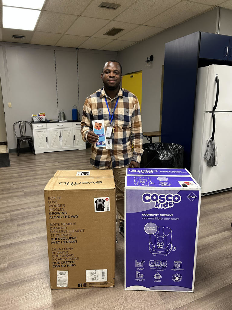 A photo of Mr. Oppong with two donated car seats from Champion for Children.