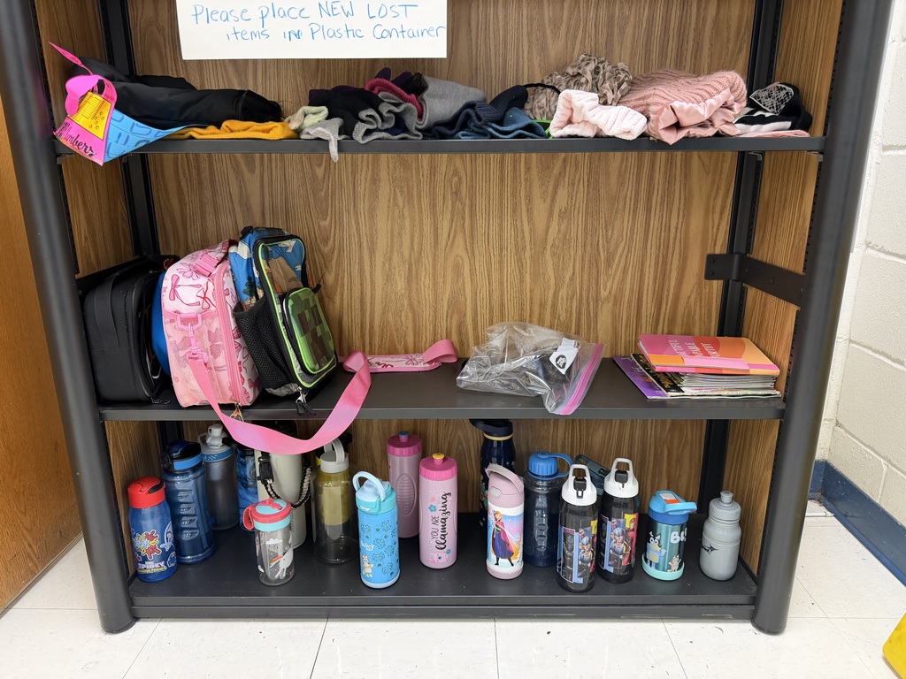 A three-tier shelf containing various lost items: the top shelf has hats and gloves; the middle shelf has lunch boxes and books; the bottom shelf holds over fifteen colorful water bottles.