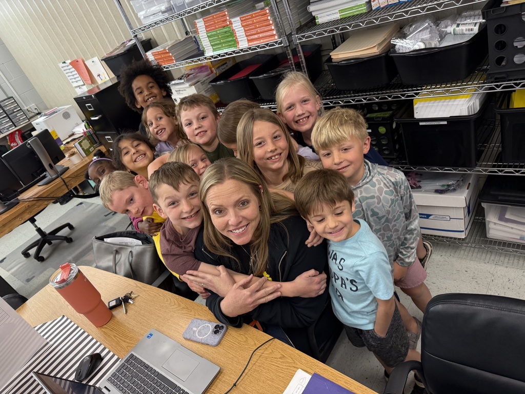 photo of assistant principal surrounded and hugged by many students
