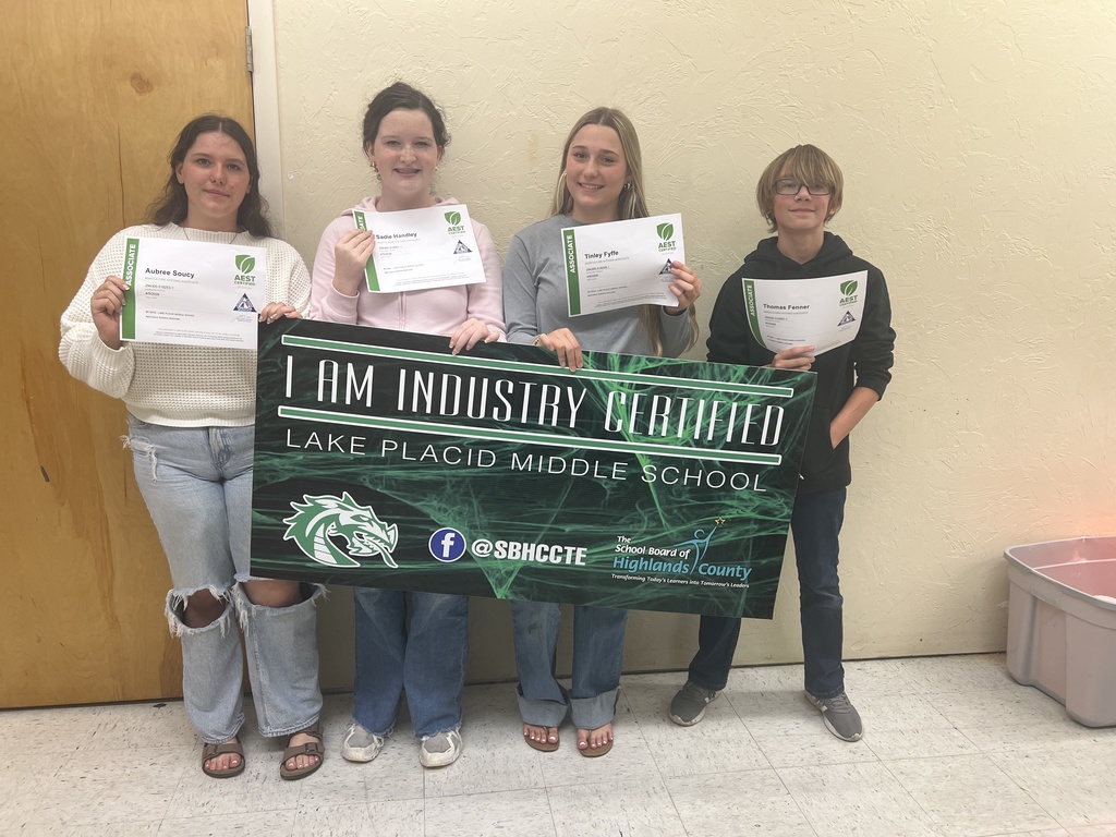 Thomas Fenner, Sadie Handley, Tinley Fyffe, Aubree Soucy  showing they are Industry Certified at Lake Placid Middle. Students are holding his certificate and the large sign. 