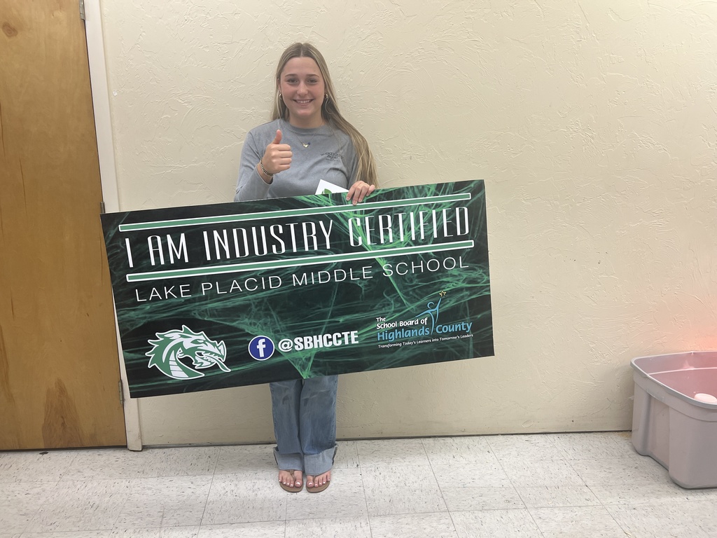 Tinley Fyffe showing she is Industry Certified at Lake Placid Middle. Student is holding her certificate and the large sign. 