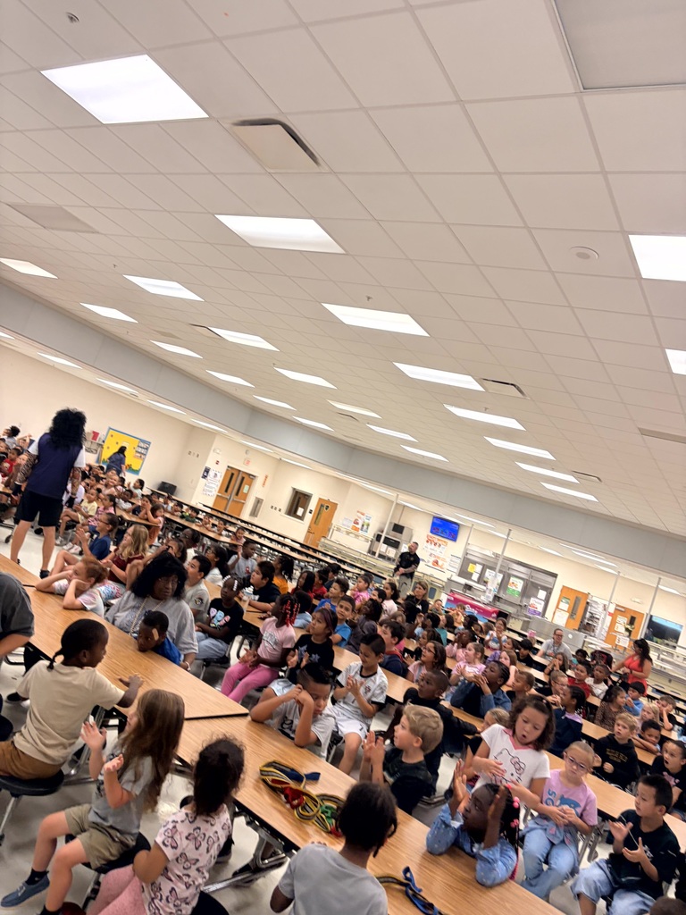 MES Pep rally students at table and cheering on for test success.