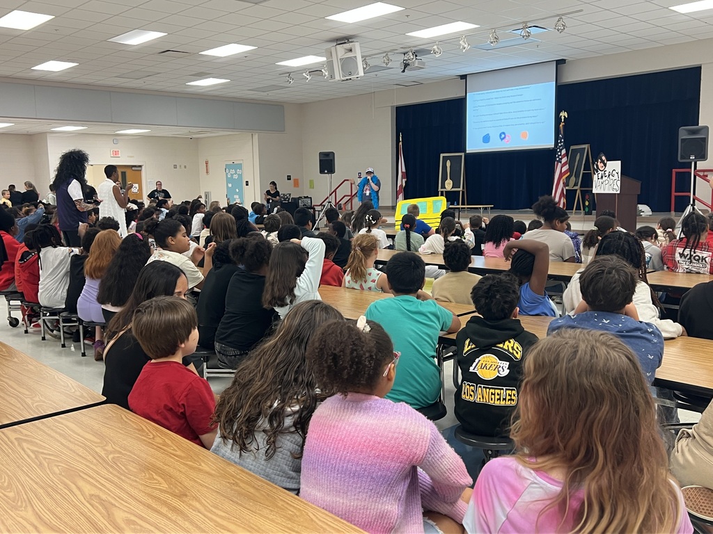 MES Pep rally students at table and cheering on for test success.