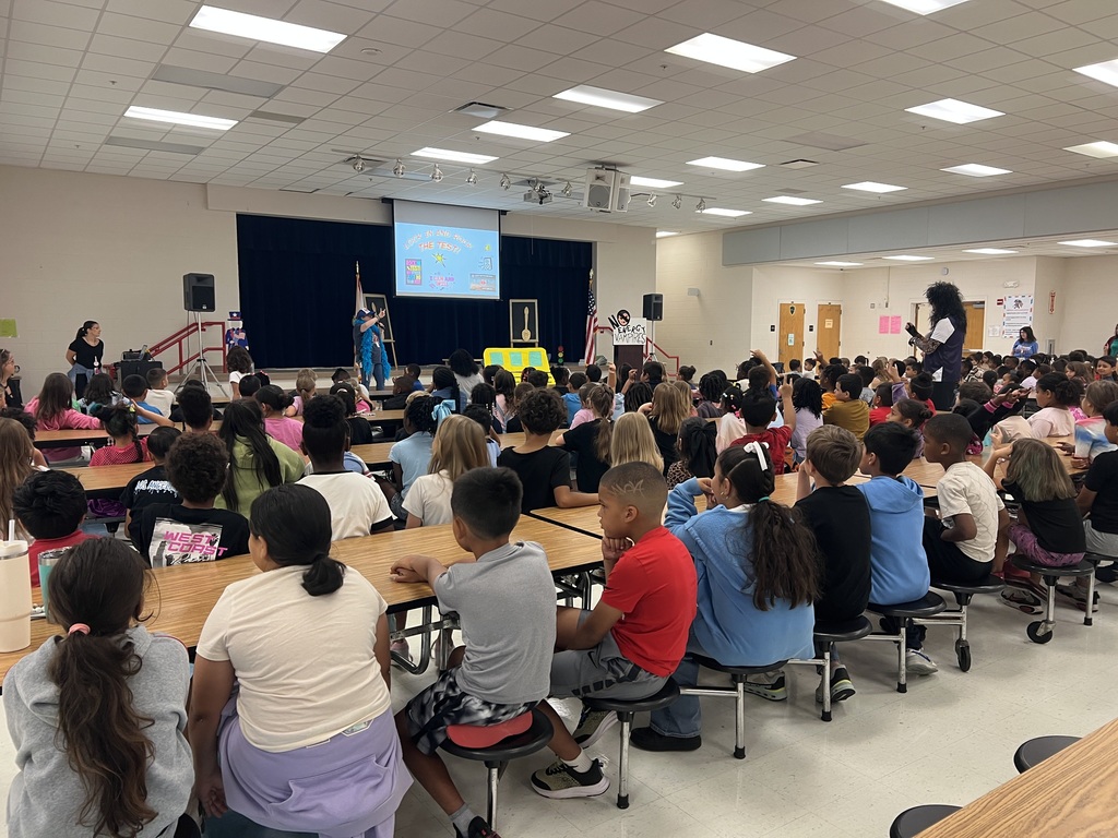 MES Pep rally students at table and cheering on for test success.