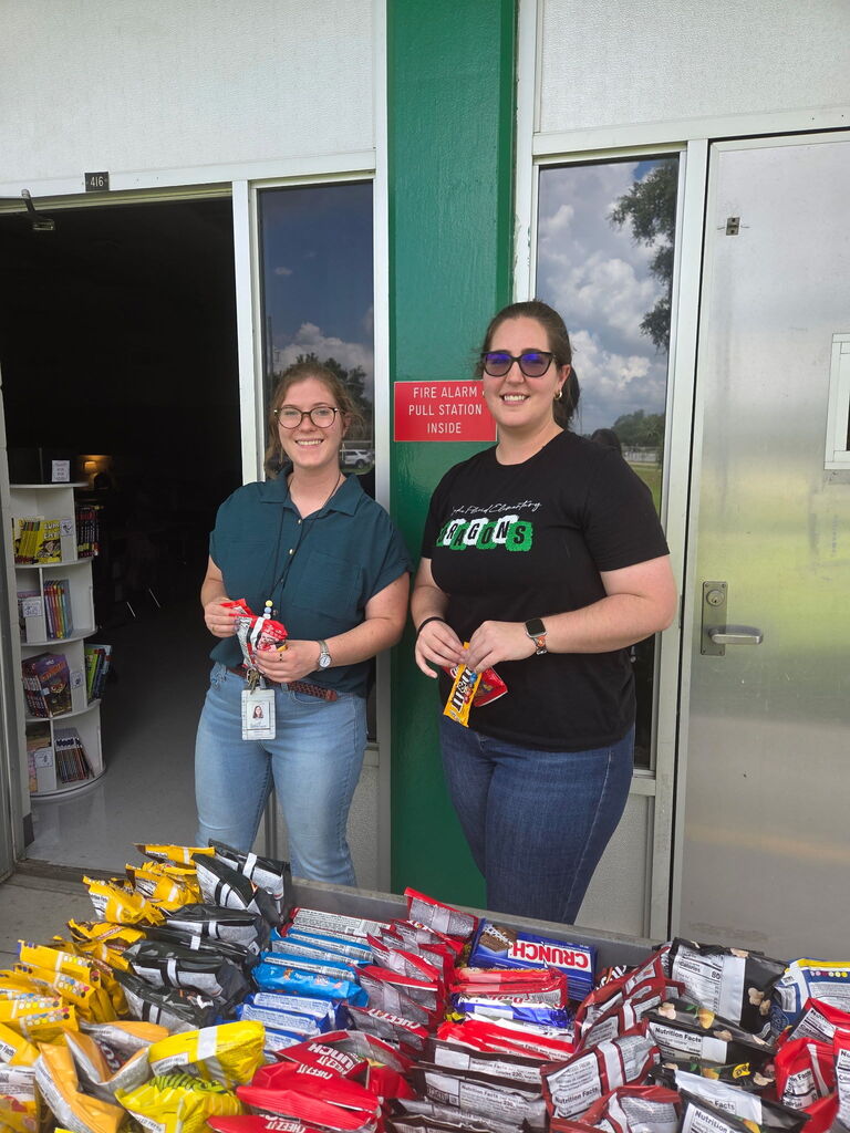 Miss Summers and Miss DiDomenico holding treats from the Dragon Wagon