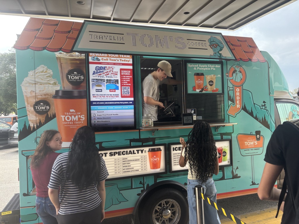 Students ordering drinks at the window of a Travelin' Tom's Coffee Truck.