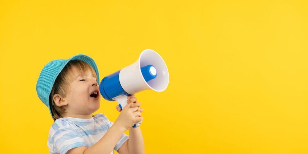 Child with bullhorn on yellow background