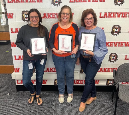 Staff members holding a legacy sign.