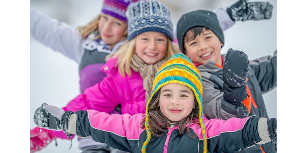 photo of 4 students wearing a winter coat and hat