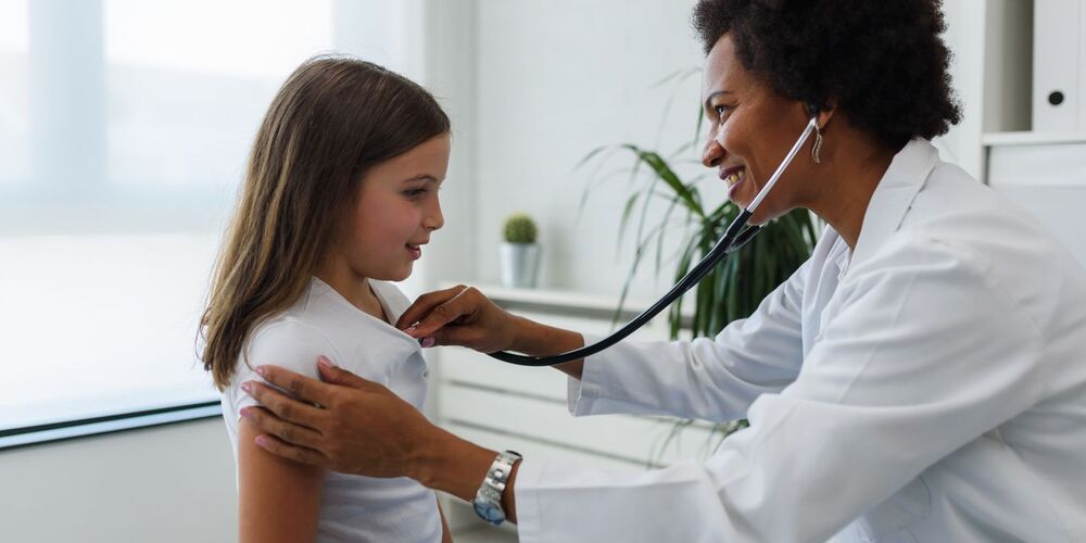 Female doctor giving a medical physical to a female child