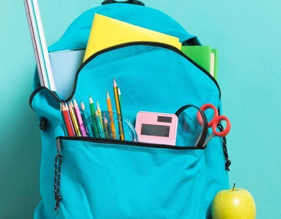 Blue backpack with school supplies coming out of the pockets.